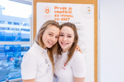 Studentky 2. lékařské fakulty před studijním stánkem, který se věnoval prvním třem ročníkům Všeobecného lékařství. 